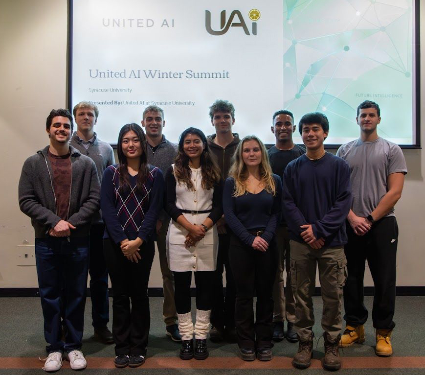 Group of students standing together in front of a United AI Winter Summit presentation slide.