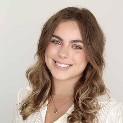 A student smiles while posing for a headshot.