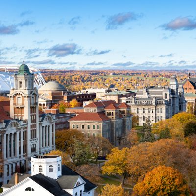 Aerial view of a historic university campus with stone buildings and autumn foliage.