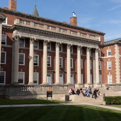 Students sit on the steps of Maxwell Hall, home of the Maxwell School of Citizenship and Public Affairs.