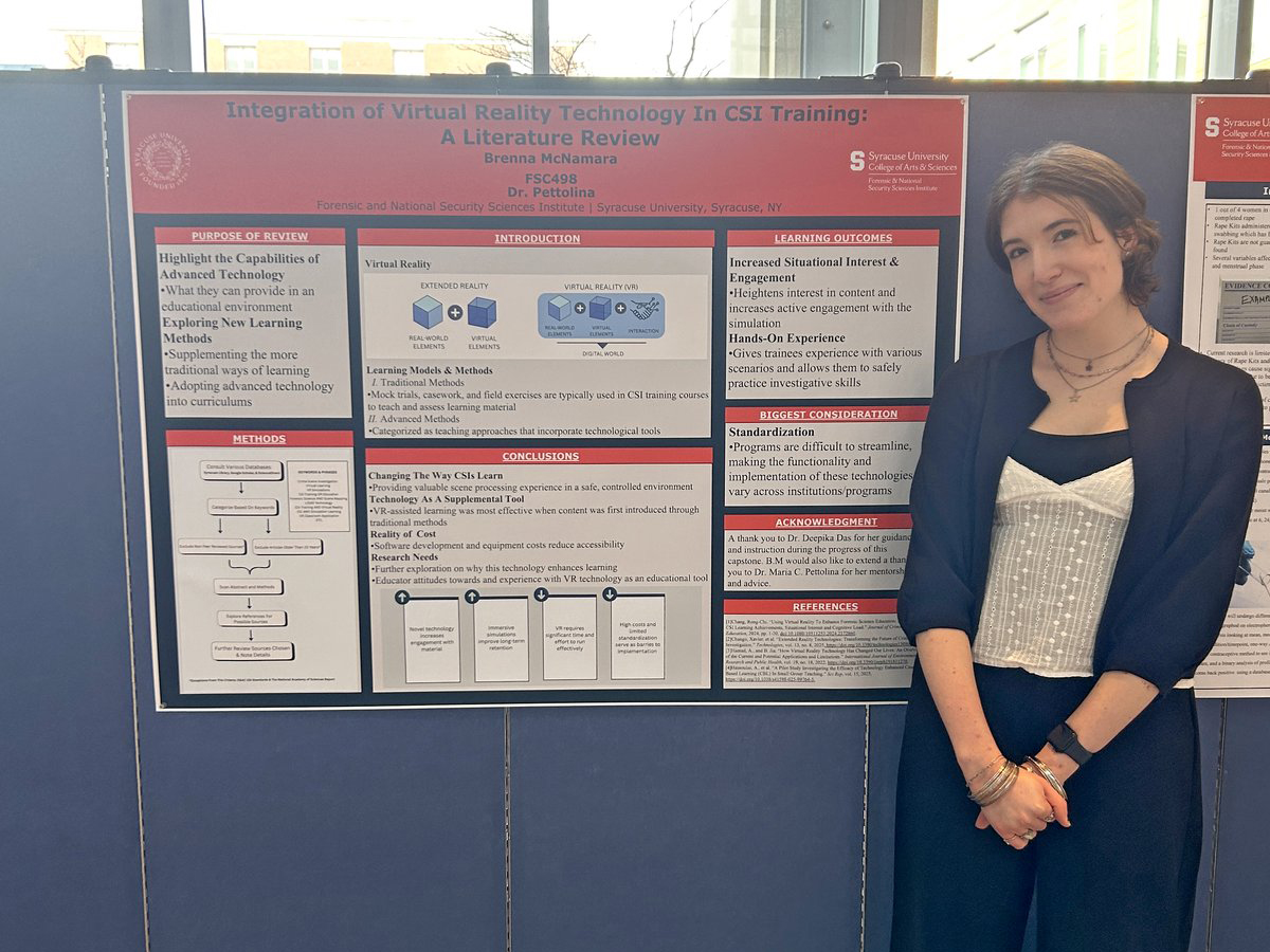 A student stands next to her research poster on integrating virtual reality technology into CSI training.