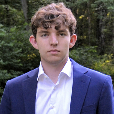 A student poses for a headshot outdoors.