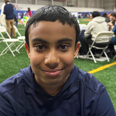 A student poses for a headshot while seated at a table.