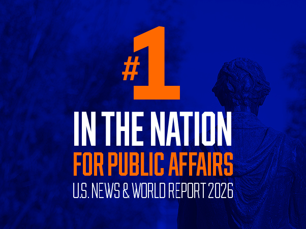 A promotional graphic with a deep blue background features bold text in white and orange reading "#1 In the Nation for Public Affairs, U.S. News & World Report 2026." The number one and the words "For Public Affairs" appear in orange; remaining text is white. A shadowed stone statue is visible in the right background