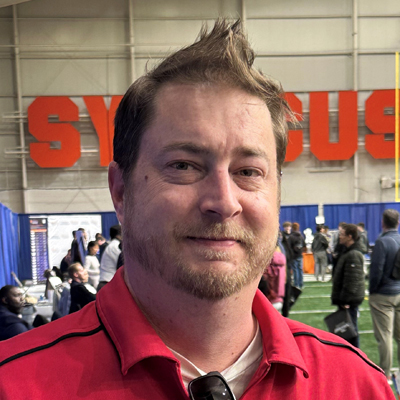 A person smiles while posing for a headshot.
