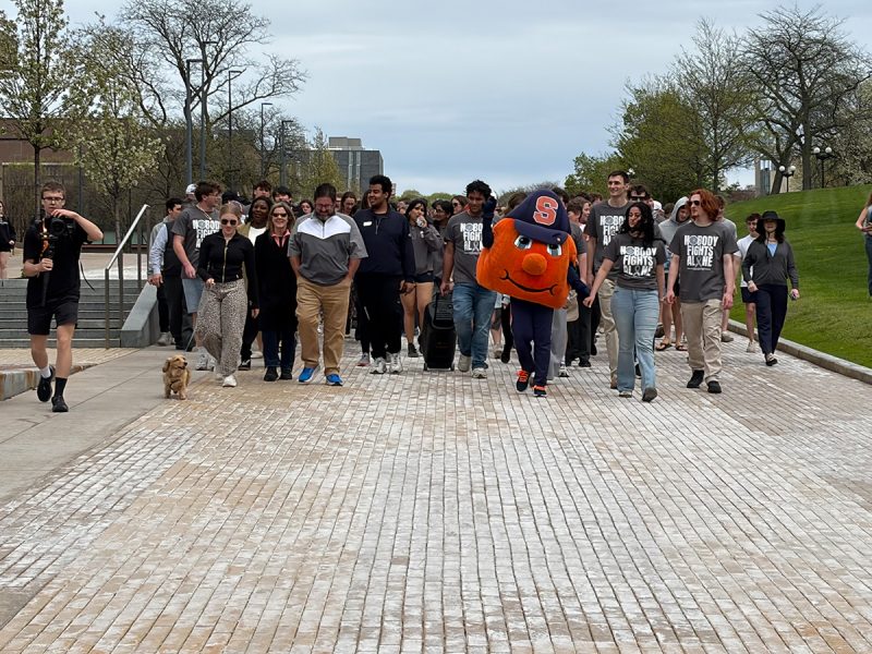 Otto the Orange leads participants down the Einhorn Family Walk to Crouse-Hinds Hall.