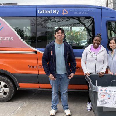 Three volunteers stand beside a Boys & Girls Clubs of Syracuse van,, with a 'Cuse Collections donation bin for household items during move-out.