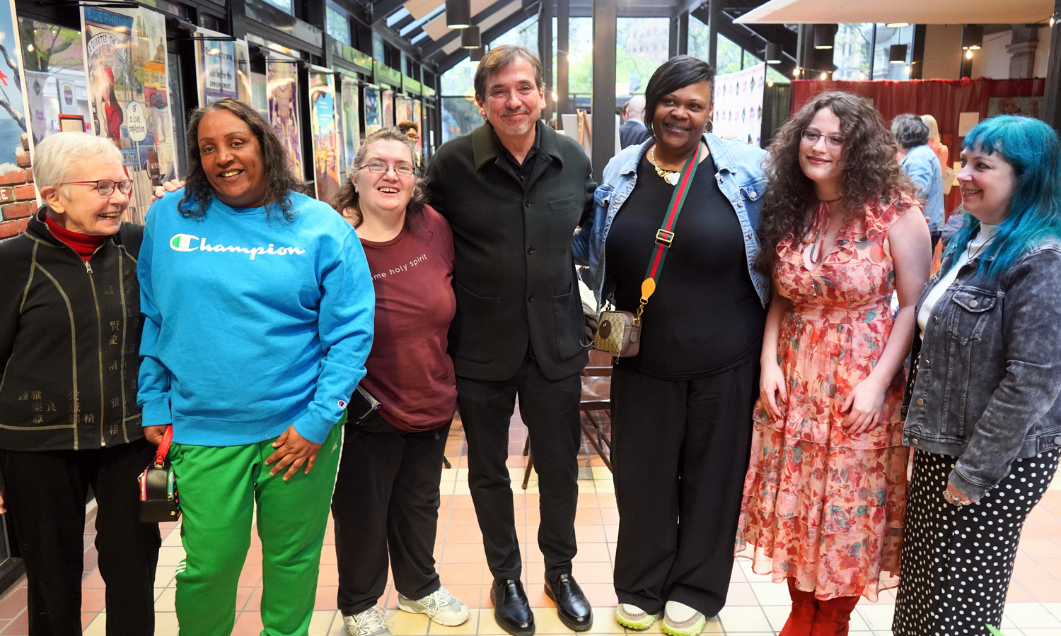 Seven people pose inside an arts venue.