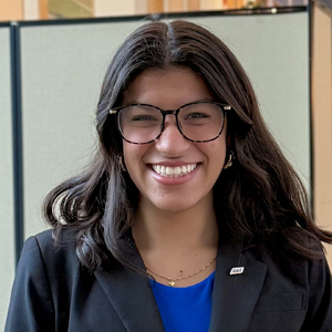 A student smiles while posing for a headshot inside.