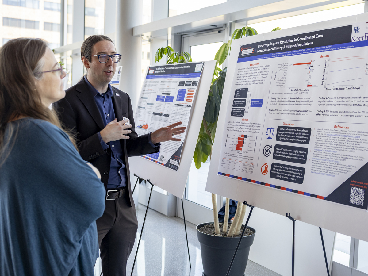 A person presents a research poster on coordinated care networks to an attendee.