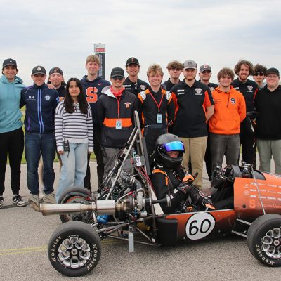 The 2025-2026 Citrus Racing Team poses with their car at the Formula SAE event in Michigan