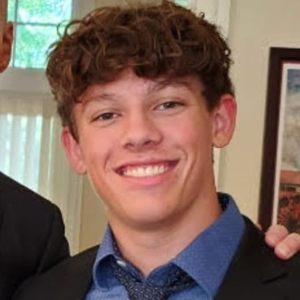 A student smiles while posing for a headshot.