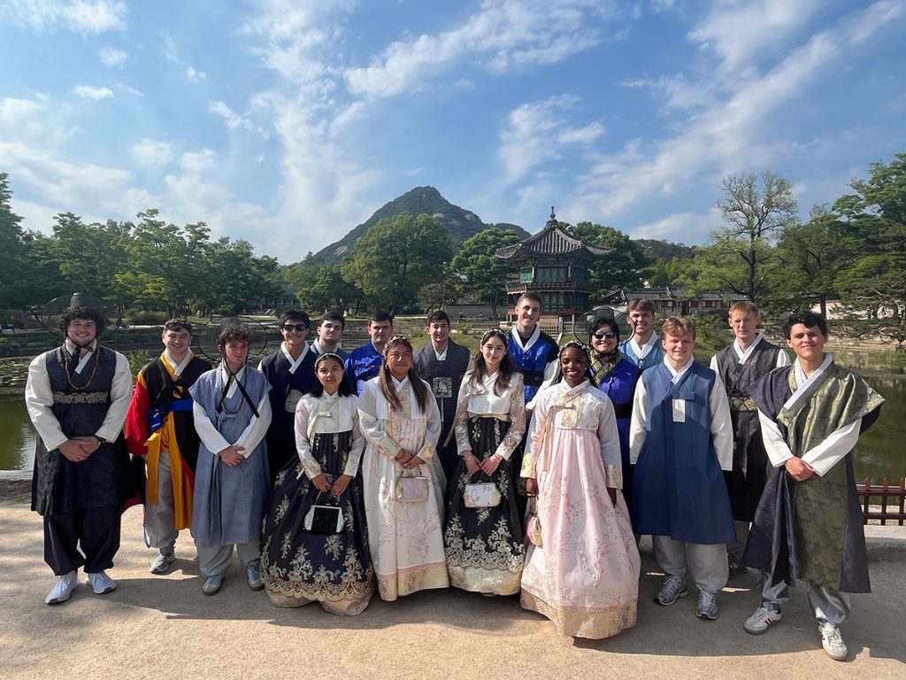 Students wearing traditional Korean hanbok gather at Gyeongbokgung Palace in Seoul, South Korea.