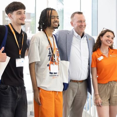 Chancellor Haynie poses with new students and orientation staff indoors.