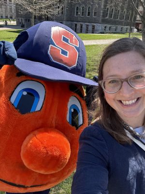 Otto poses with their coach on a sunny day on campus.