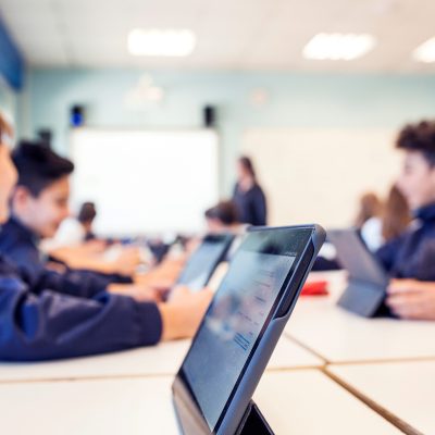 students work on tablets at their desks during class