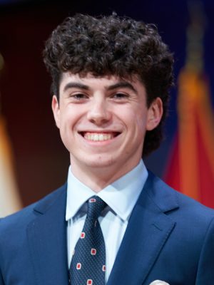 A student smiles while posing for a headshot