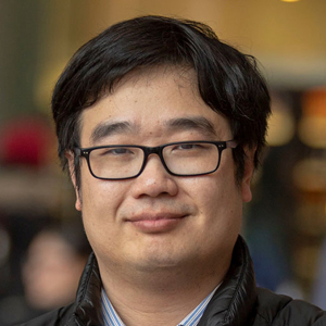 A person smiles while posing for a headshot