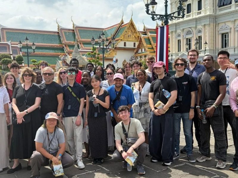 A group of students and faculty pose in front of the Grand Palace in Bangkok, Thailand.