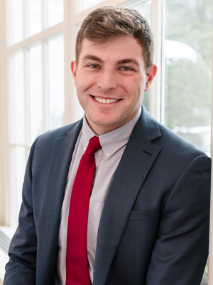 A person smiles while posing for a headshot.
