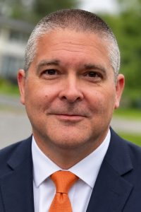 A person poses for a headshot outdoors.