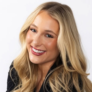 A student smiles while posing for a headshot indoors.