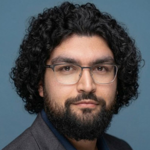 A student poses for a headshot in front of a grey backdrop.