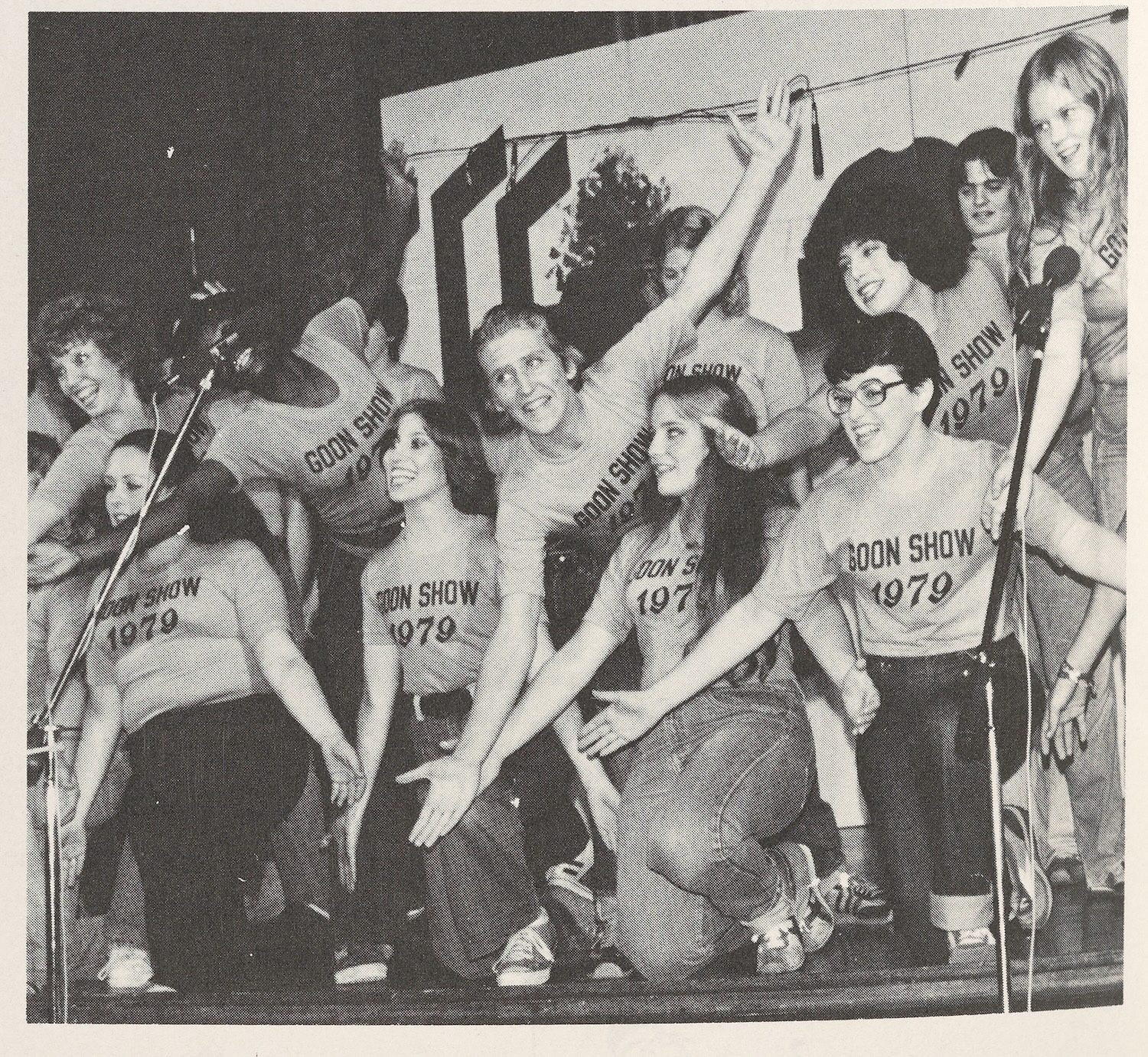 Group of students wearing “Goon Show 1979” shirts performing on stage during a campus event.