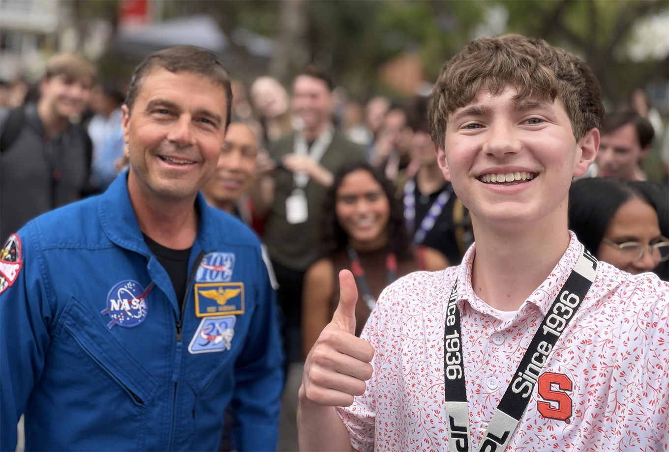Andrew Uryniak giving thumbs up next to astronaut Reid Wiseman