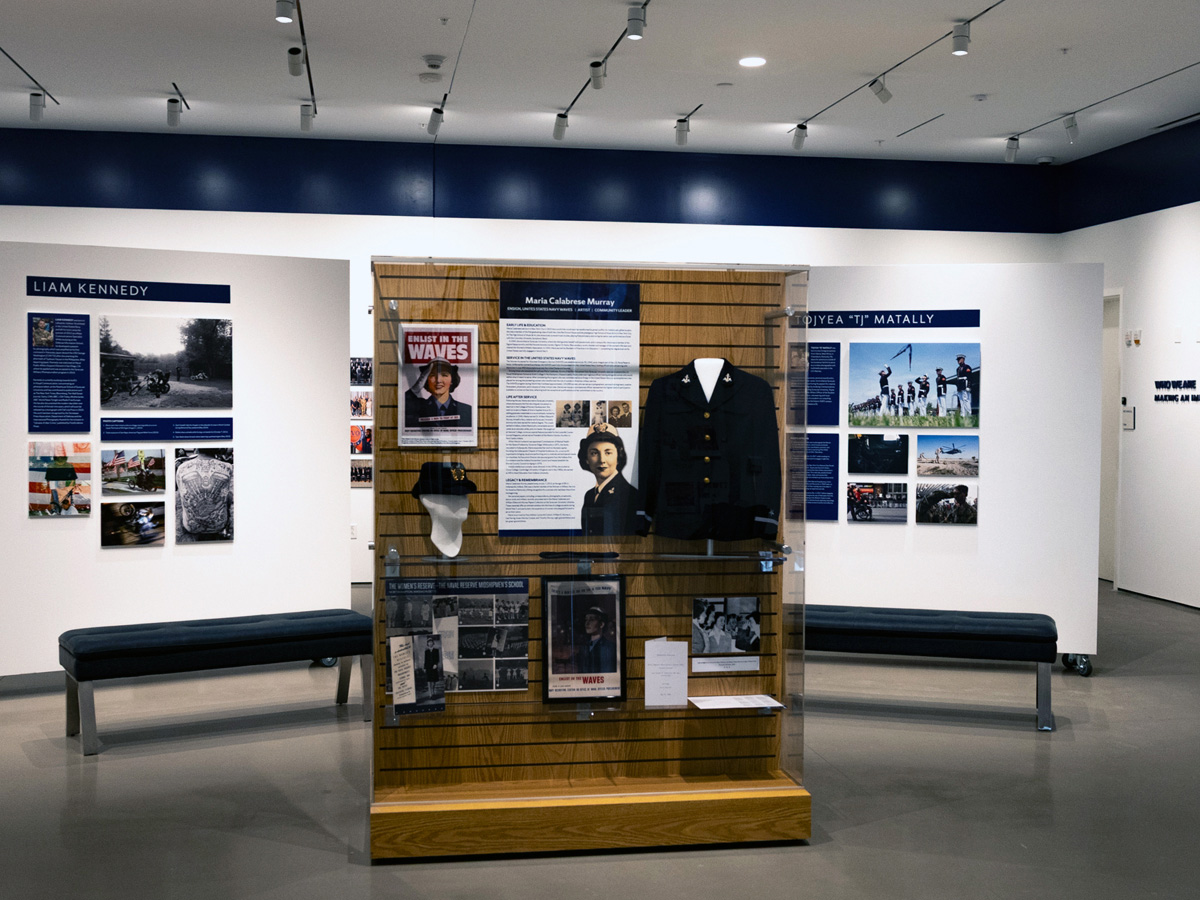 Museum gallery displaying Maria Calabrese Murray's WAVES uniform and exhibit panels