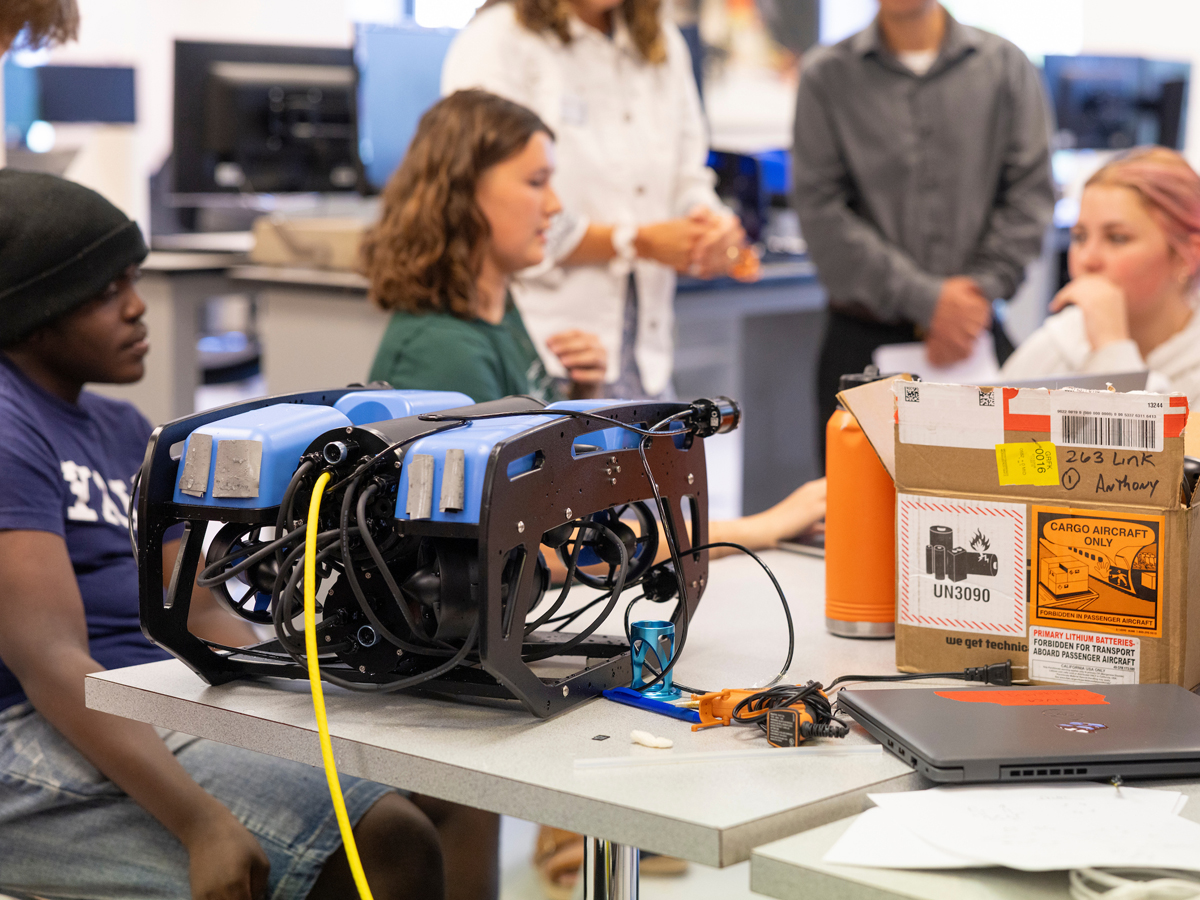 Students discuss an underwater submersible robot in Orange Works.