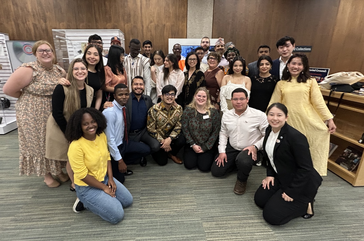 Large group photo of students and staff gathered indoors to celebrate a program completion event.