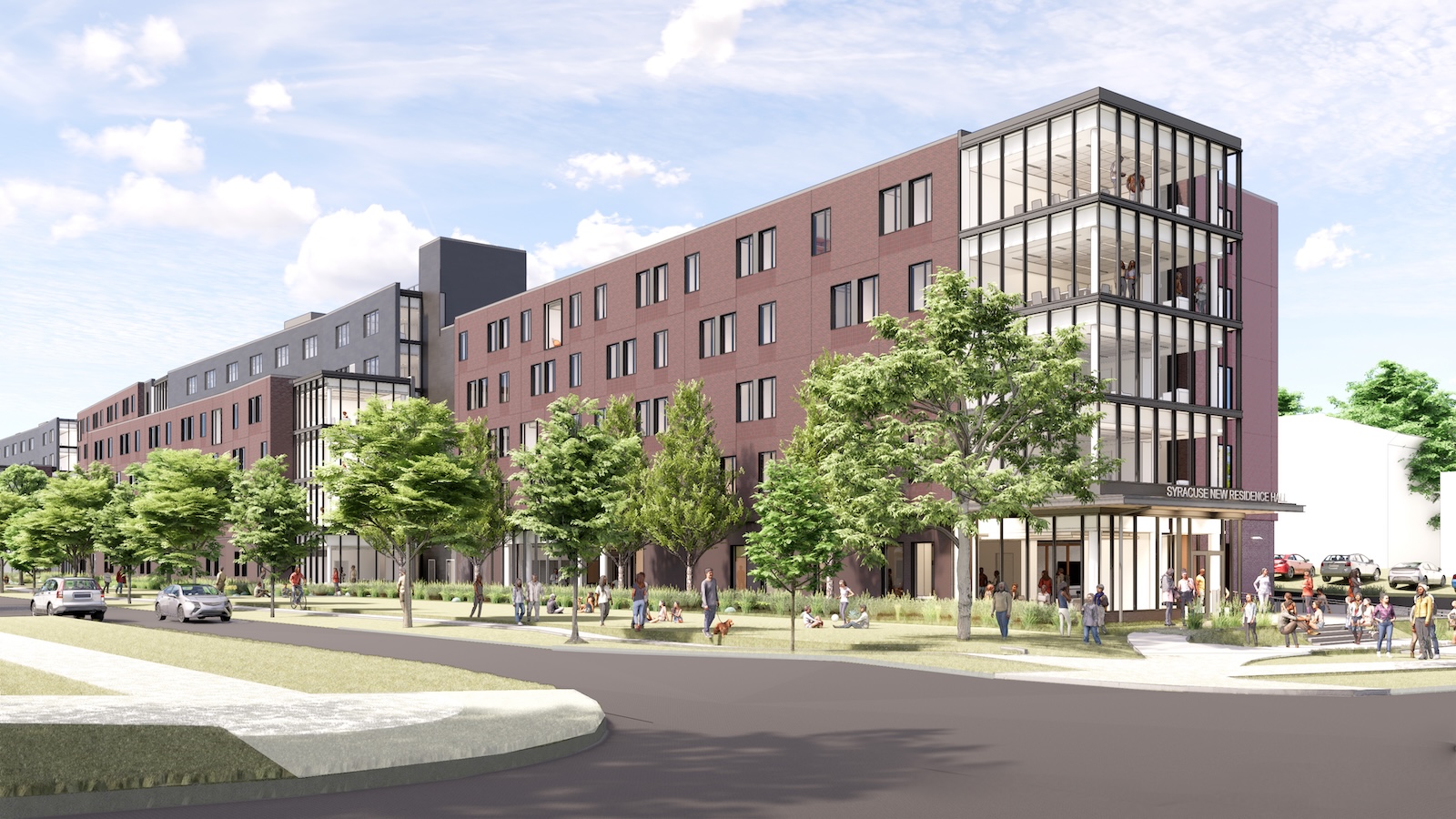 Street view of a modern residence hall with landscaped green space, glass corner lounges, and students gathered outside.