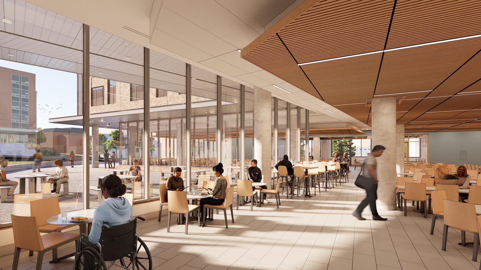 Bright, glass-lined dining hall with accessible seating, wood-paneled ceilings, and views of an outdoor courtyard.