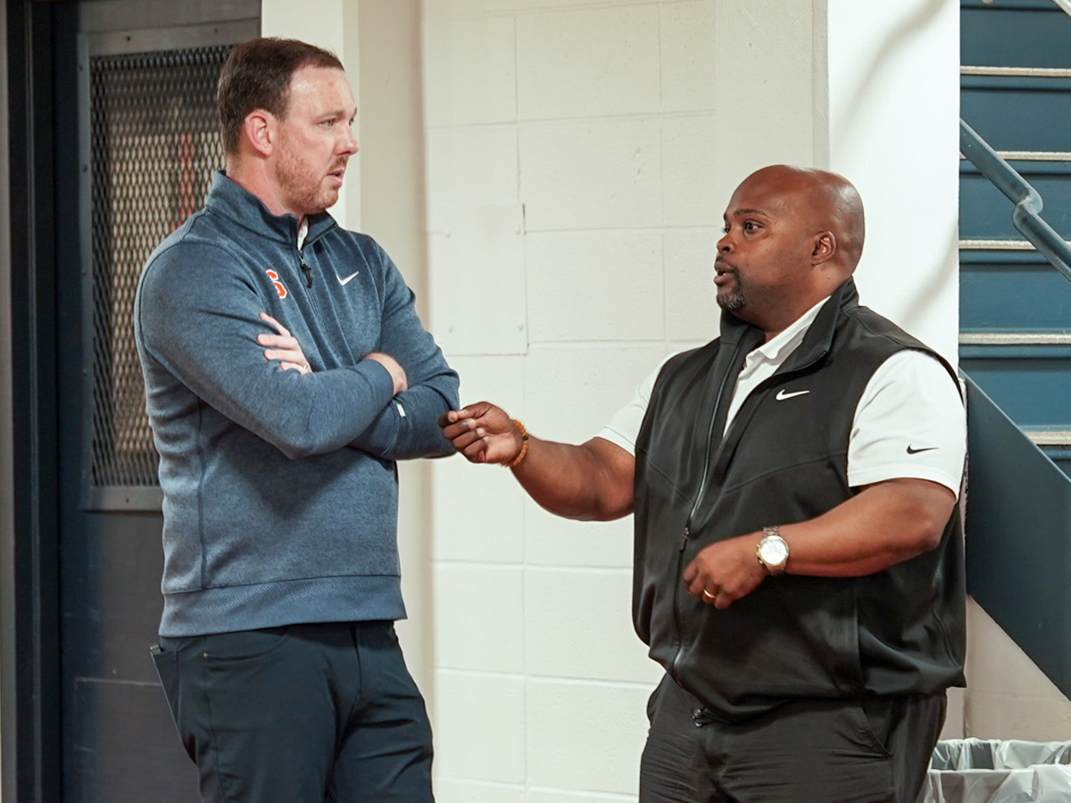 Bryan Blair speaks with Gerry McNamara during a conversation near a stairwell.