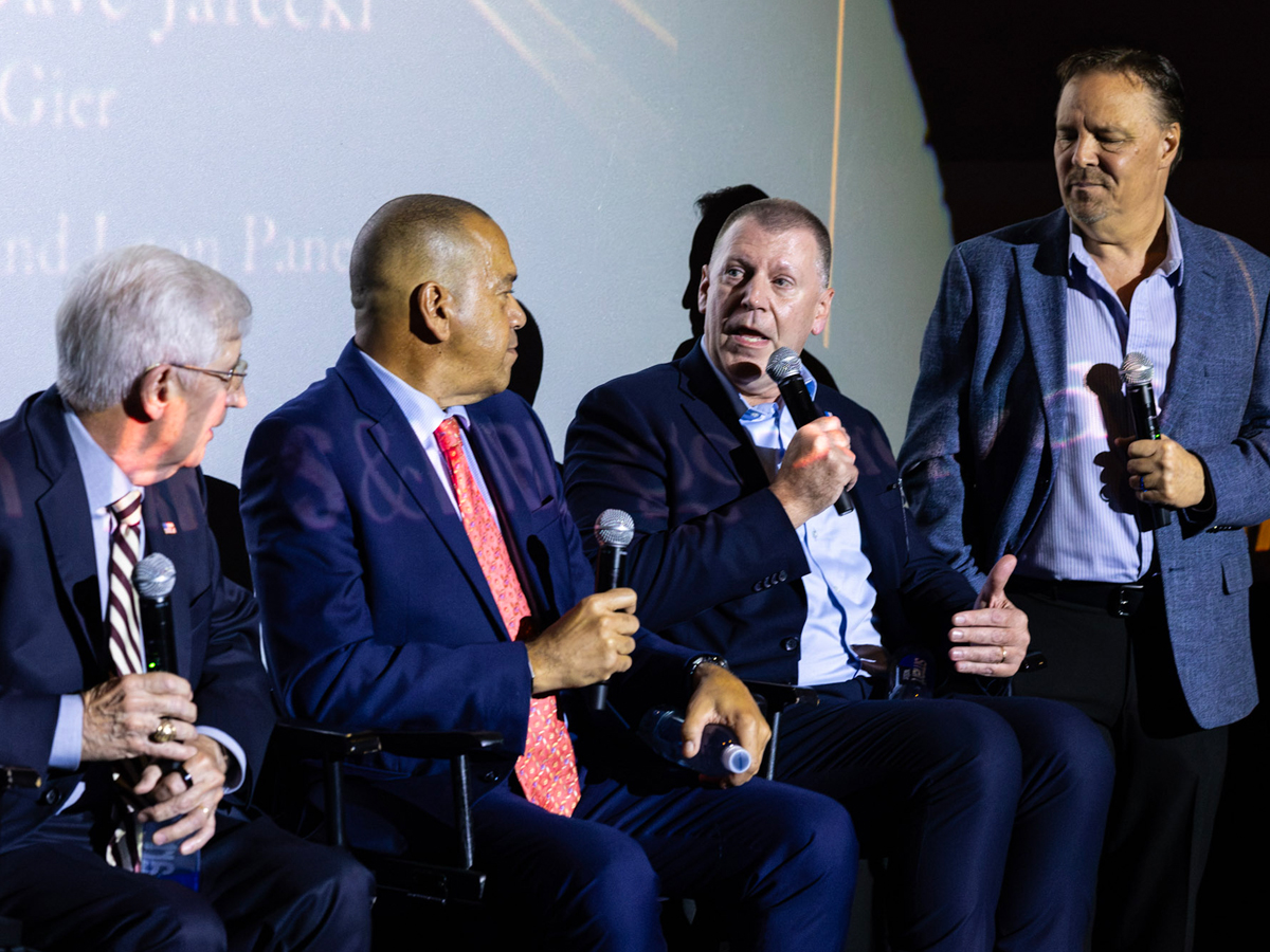 Four panelists with microphones discuss the 9/11 documentary on stage.