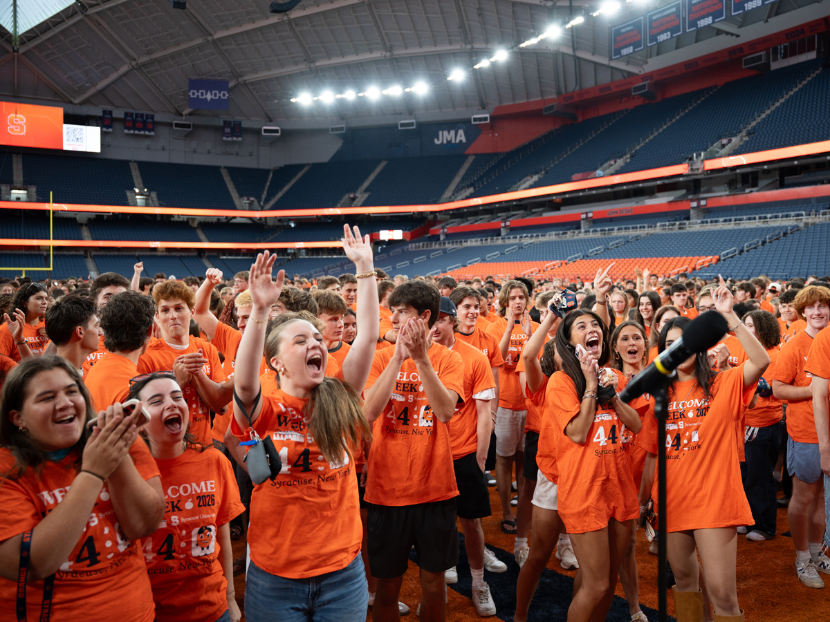 Students in orange Welcome Week shirts cheer inside the JMA Dome
