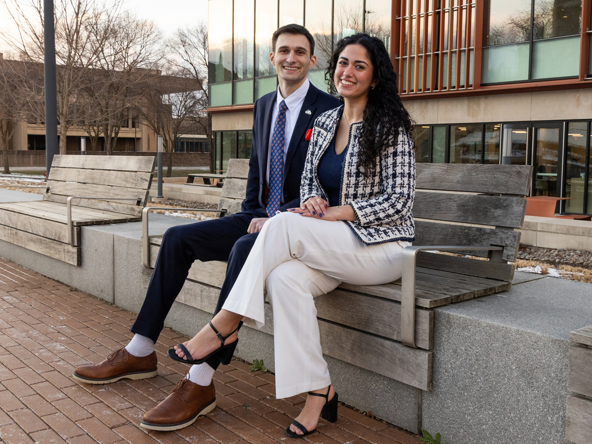 Two student government leaders sitting on a park bench.