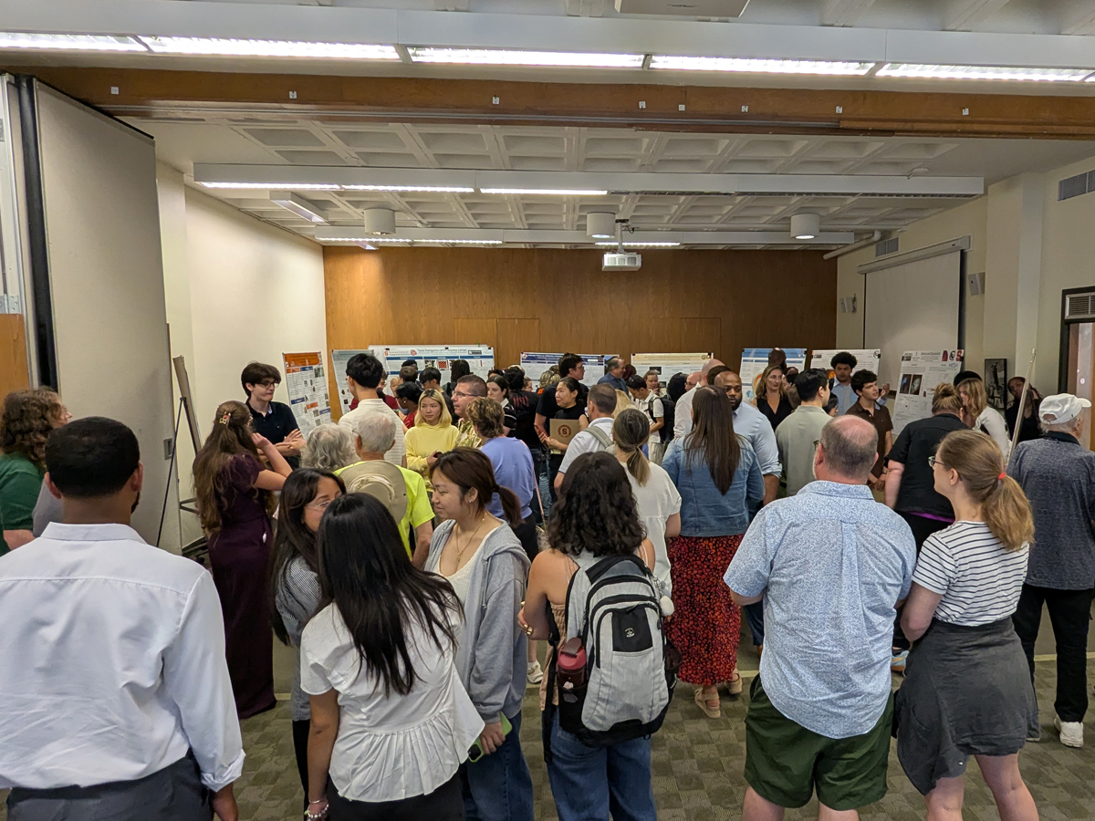Crowd views research posters at a SU-SHIP poster session.