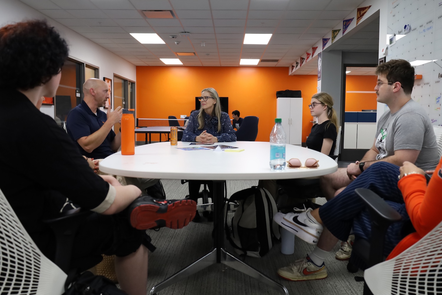 Small group gathered around a conference table in a collaborative discussion space.