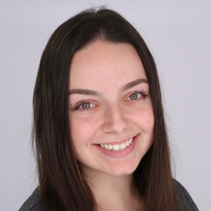 A person smiles while posing for a headshot