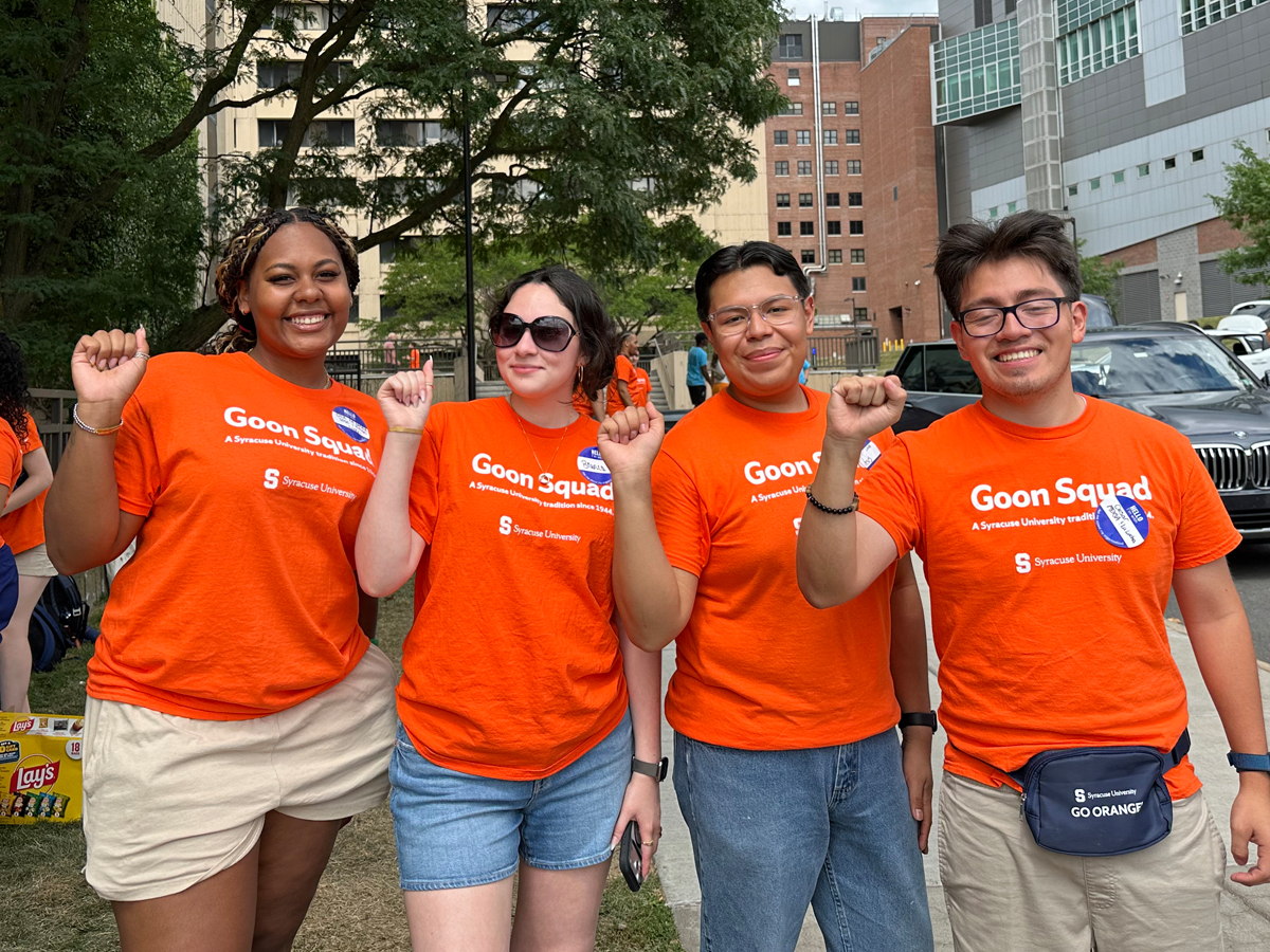 Four students in orange Goon Squad T-shirts help out with move-in.