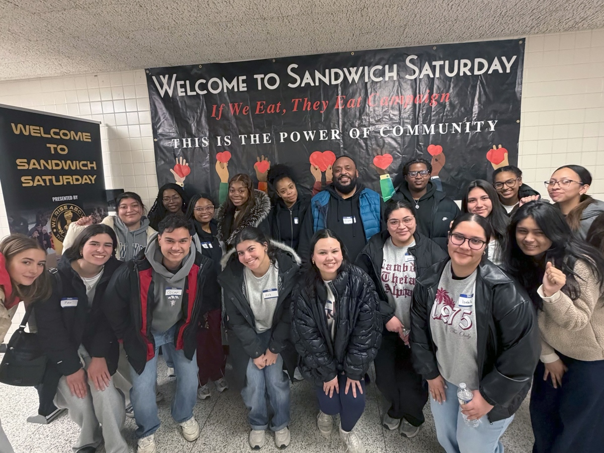 Students and volunteers pose after volunteering during Sandwich Saturdays.
