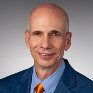 A person smiles while posing for a headshot