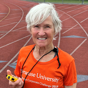 A person smiles while holding a stopwatch.